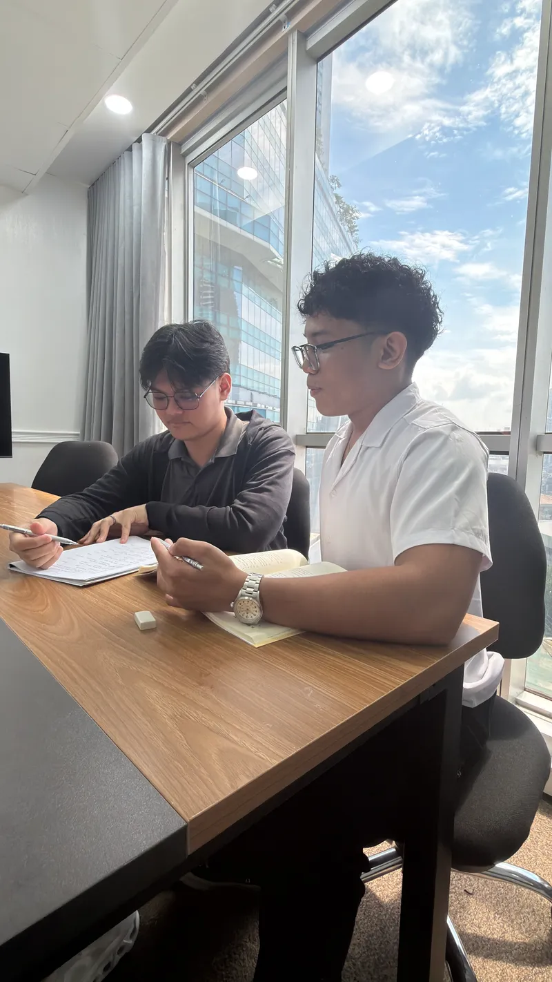Jose and Roland discussing notes at a table