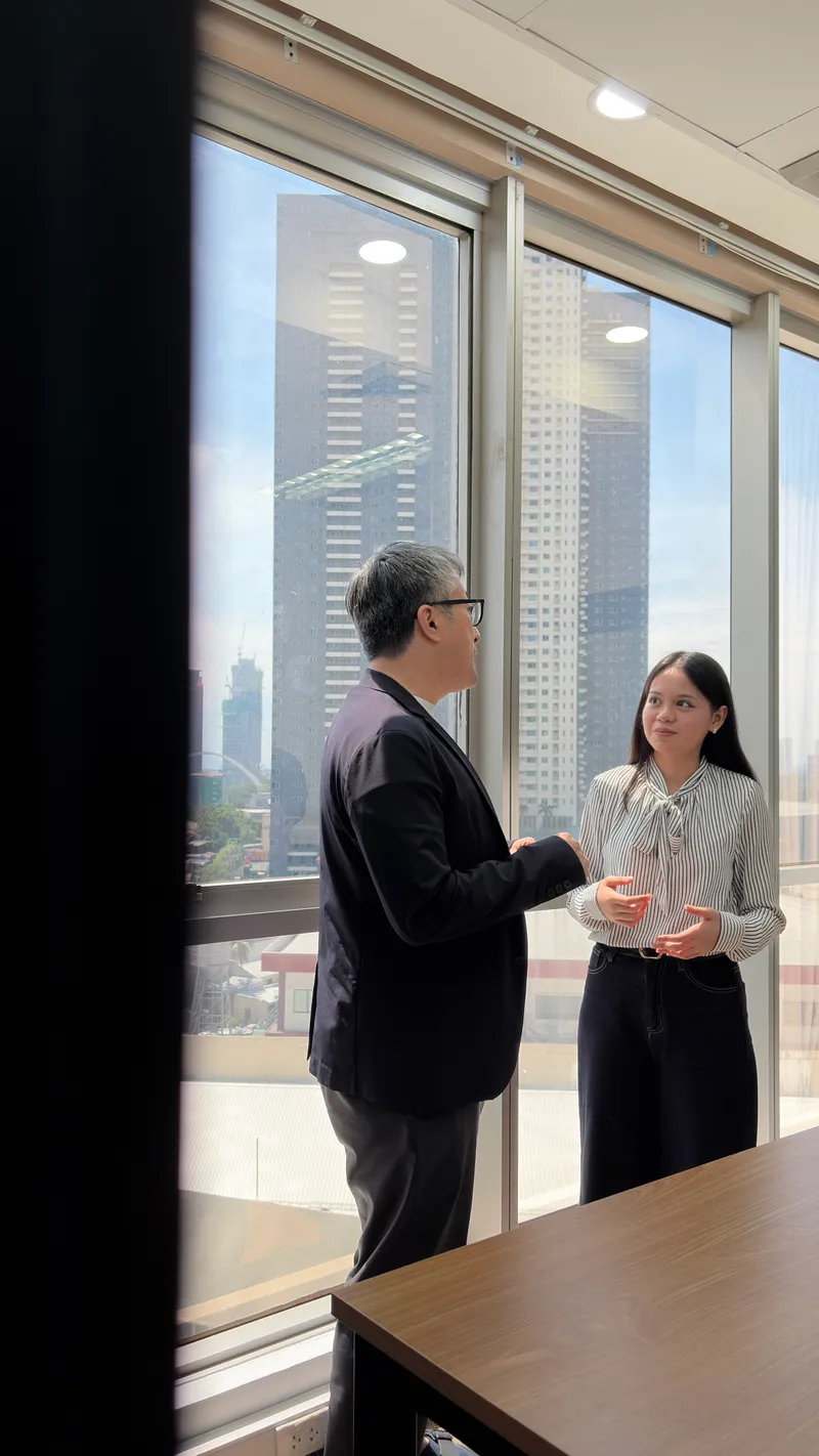 Makino talking with a colleague in the office