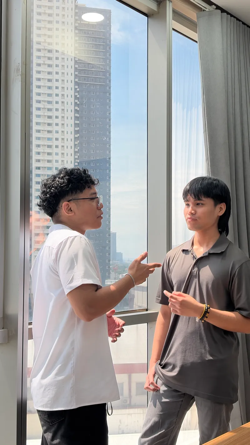 Warren and Roland having a conversation by the window